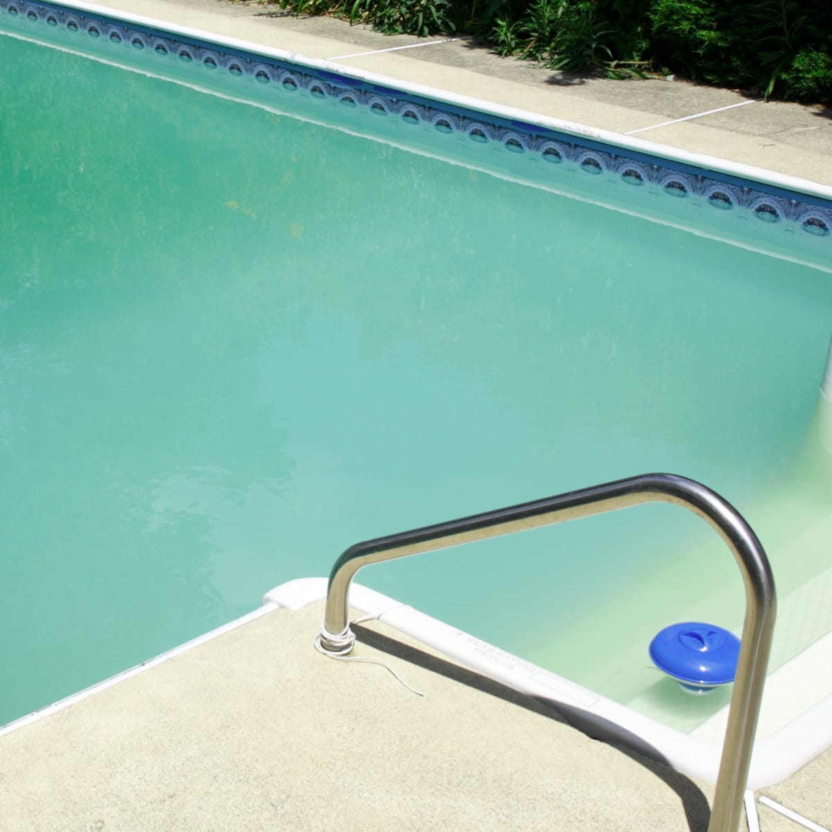 What are the dark brown and orange spots on the bottom of my pool caus